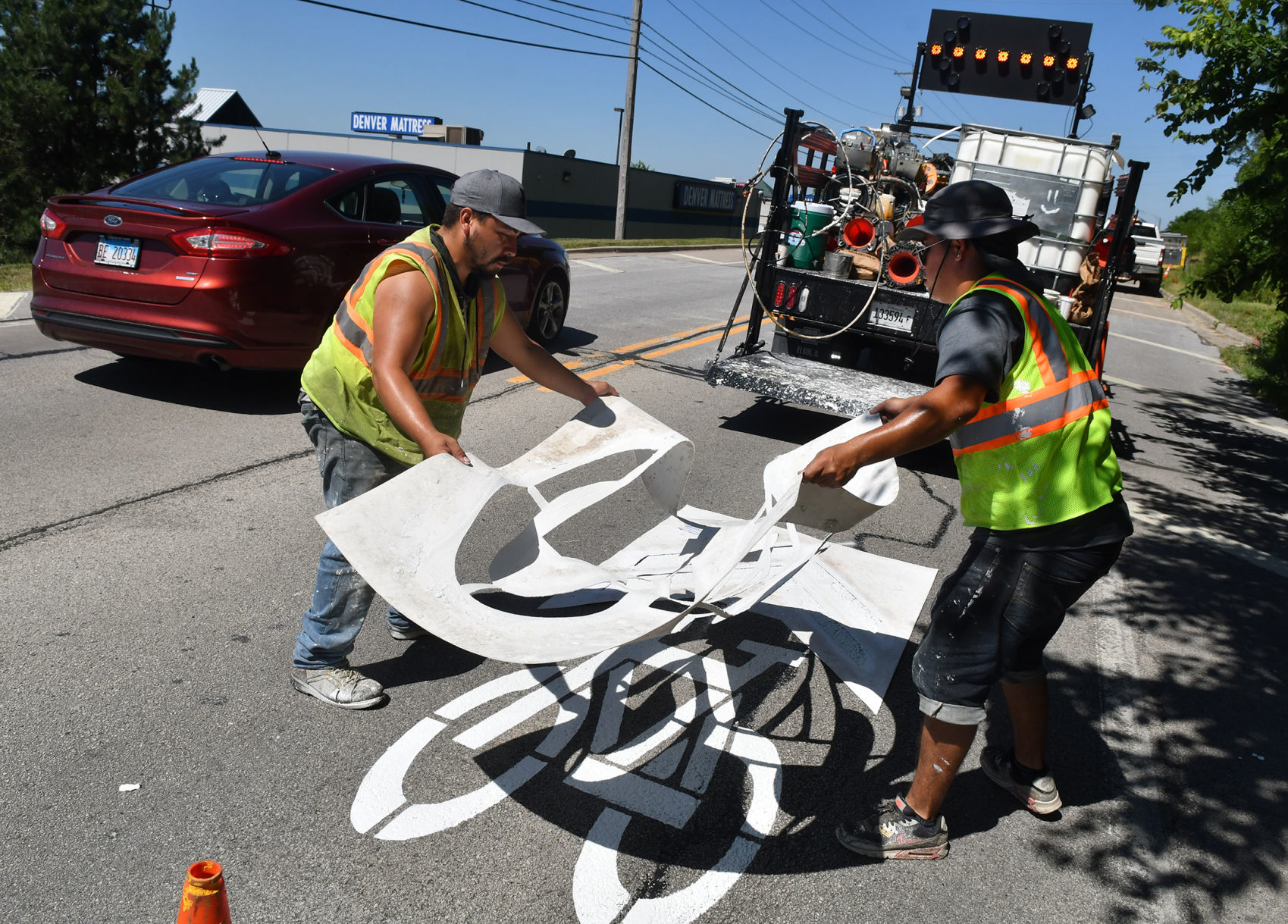 Painting of sharrows for bike lanes in Moline.